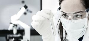 Female Scientist Looking at Tube