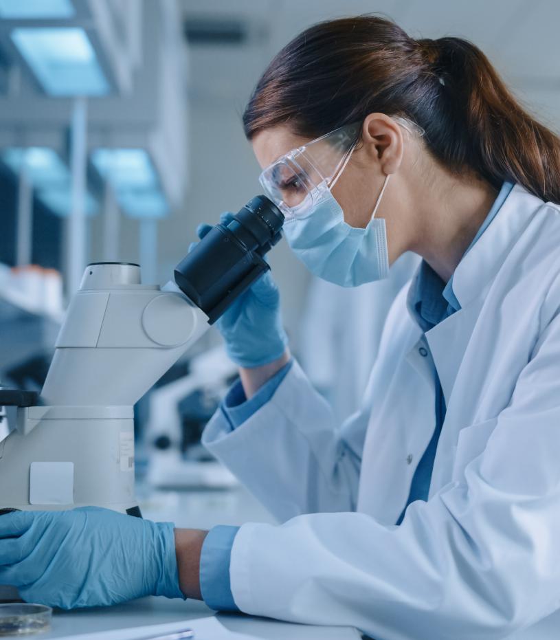 Female Scientist using a Microscope