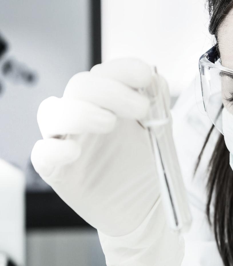 Female Scientist Looking at Tube